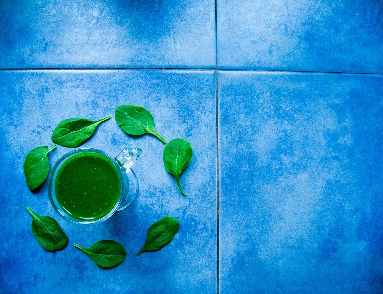 Polvere di spirulina in un cucchiaio, simbolo dei benefici per il dimagrimento e la salute.